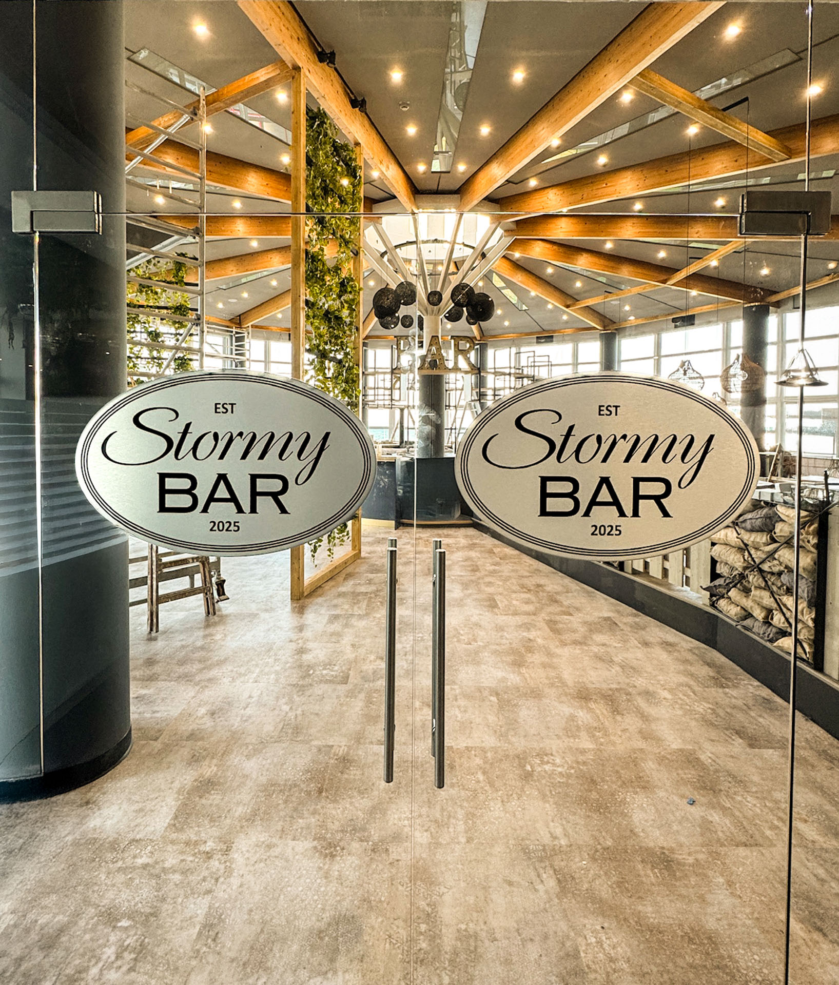 Glass doors with "StormyBAR Logos an der Tür, modern eingerichtet.